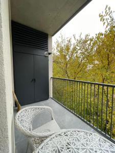 a white wicker chair sitting on a balcony at Luxury Apartment Pekini in Tbilisi City +1 photo