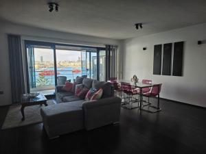 a living room with a couch and a table with chairs at Sea View over Valletta Harbour 3 bedrooms 2 S4 in Sliema