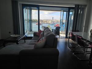 a living room with a couch and a view of the water at Sea View over Valletta Harbour 3 bedrooms 2 S4 in Sliema