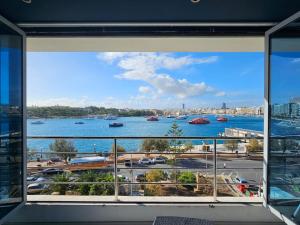 a view of a harbor from a window at Sea View over Valletta Harbour 3 bedrooms 2 S4 in Sliema