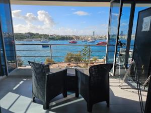 a balcony with a table and chairs and a view of the water at Sea View over Valletta Harbour 3 bedrooms 2 S4 in Sliema