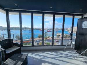 a room with a large window with a view of the water at Sea View over Valletta Harbour 3 bedrooms 2 S4 in Sliema