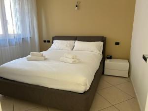 a bedroom with a bed with two towels on it at House Trenno in Milan