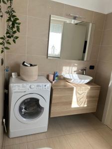 a bathroom with a washing machine and a sink at House Trenno in Milan