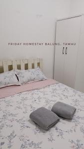 a bedroom with a bed with two pillows on it at Friday Homestay Taman Sawit Balung, Tawau in Tawau