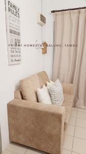 a brown couch with pillows on it in a room at Friday Homestay Taman Sawit Balung, Tawau in Tawau +2 photos