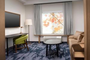 una camera d'albergo con divano, scrivania e finestra di Fairfield Inn & Suites by Marriott Knoxville Lenoir City/I-75 a Lenoir City
