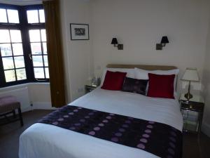 a bedroom with a large bed with red pillows at Royal Hotel (Adults Only) in Eastbourne