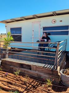 een vrouw op de veranda van een trailer bij Quentin Park Hideaway 1 in Peterborough