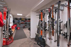 a room with a bunch of skis hanging on a wall at GH Hotel Piaz in Pozza di Fassa