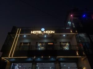 a hotel sign on the side of a building at night at Hotel Moon in Mahoba