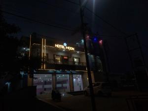 a building with a neon sign on it at night at Hotel Moon in Mahoba