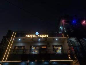 a hotel sign on the side of a building at night at Hotel Moon in Mahoba