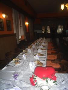 una mesa larga con platos de comida. en Hotel Grand en Tanvald