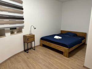 a bedroom with a bed with blue sheets and a lamp at POLAT Apartments 8 in Essen