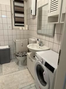 a bathroom with a washing machine and a sink at POLAT Apartments 8 in Essen