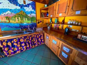 a kitchen with a sink and a painting on the wall at Hostal Las Natalias in Futaleufú