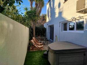 a backyard with a grill and chairs and a house at Moon location in Cap d'Agde