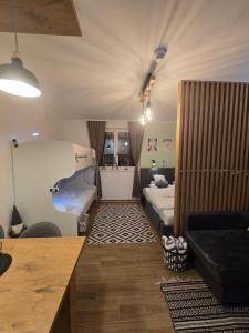 a small room with two beds and a couch at Kai Apartman in Kopaonik