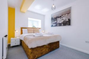 a bedroom with a large bed with white walls at Westlea in Leeds