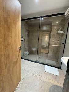 a bathroom with a glass shower and a toilet at HOTEL TOUCHWOOD in Visakhapatnam