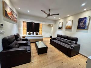 a living room with black leather furniture and a bed at HOTEL TOUCHWOOD in Visakhapatnam