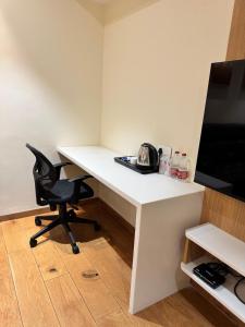 a white desk with a chair and a television at HOTEL TOUCHWOOD in Visakhapatnam