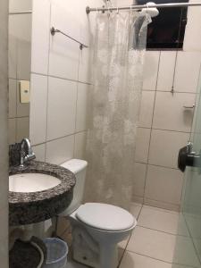 a bathroom with a toilet and a sink and a shower at Hotel Faria in Piauí +16 photos