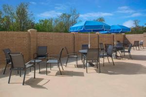a group of tables and chairs with blue umbrellas at Fairfield Inn & Suites by Marriott Cut Off-Galliano in Galliano