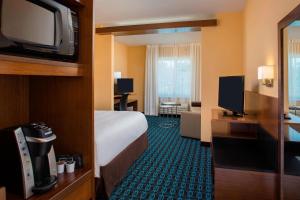 a hotel room with a bed and a flat screen tv at Fairfield Inn & Suites by Marriott Cut Off-Galliano in Galliano
