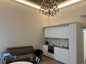 a living room with a couch and a chandelier at Les Suites di Parma - Cavour in Parma