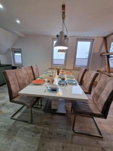a dining room with a white table and chairs at Mikes Fewo in Hohegeiß