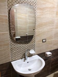 ein Badezimmer mit Waschbecken und Spiegel in der Unterkunft luxury apartment in wesal residence compund in Kairo