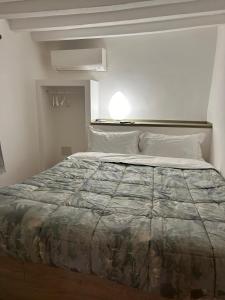 a bedroom with a large bed in a white room at Les Suites di Parma - Cavour in Parma