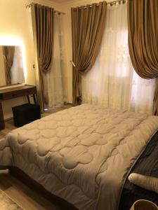 ein großes Bett in einem Schlafzimmer mit Fenster in der Unterkunft luxury apartment in wesal residence compund in Kairo