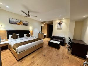 a bedroom with a bed and a desk and a couch at HOTEL TOUCHWOOD in Visakhapatnam