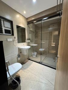 a bathroom with a shower and a toilet and a sink at HOTEL TOUCHWOOD in Visakhapatnam