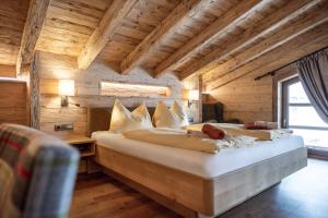 sypialnia z 2 łóżkami w pokoju z drewnianym sufitem w obiekcie Hotel Garni Ransburgerhof w mieście Flachau