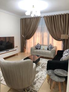 ein Wohnzimmer mit Sofa und Fernseher in der Unterkunft luxury apartment in wesal residence compund in Kairo + 30 Fotos