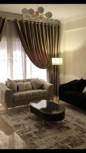 ein Wohnzimmer mit einer Couch und einem Couchtisch in der Unterkunft luxury apartment in wesal residence compund in Kairo