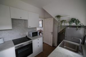 a kitchen with white cabinets and a sink and a refrigerator at 2 Bedroom House By Travel Lets Holiday Homes Belfast In City Centre With Free Parking in Belfast