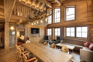 salon z dużym drewnianym stołem i krzesłami w obiekcie Hotel Garni Ransburgerhof w mieście Flachau