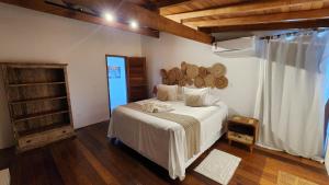 a bedroom with a white bed and a large window at Pousada Vila do Mar in Caraíva