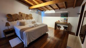 a bedroom with a large bed and a piano at Pousada Vila do Mar in Caraíva