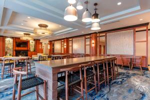 a bar in a restaurant with tables and chairs at Fairfield Inn & Suites Columbus in Columbus
