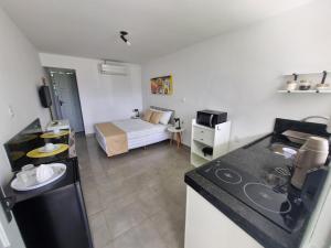Una habitación con cocina y un dormitorio con cama. en RC FLATS apts 02 e 04, en Tamandaré