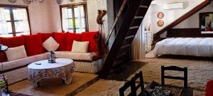 a living room with a red couch and a bed at Phedra's House Spata- Artemida in Artemida