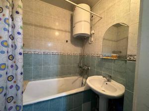 un baño con lavabo y bañera en Nuri, en Karakol 13 fotos más