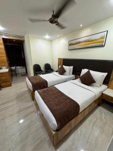 a hotel room with two beds and a ceiling at HOTEL TOUCHWOOD in Visakhapatnam