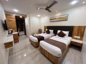 a hotel room with two beds and a television at HOTEL TOUCHWOOD in Visakhapatnam